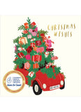 A Christmas-themed card design featuring a red vintage car filled with a decorated Christmas tree and wrapped gifts, with the words 'CHRISTMAS WISHES' in gold on a cream background. A circular badge at lower left reads 'Jeano For Games' and 'Children's Medical Research'.
