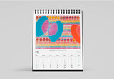 Colourful spiral-bound calendar with abstract design on a gray background