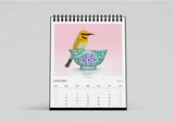 Calendar with a bird and floral design on a pink background