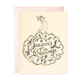 A Christmas card with a Peace Dove with the words Seasons greetings.