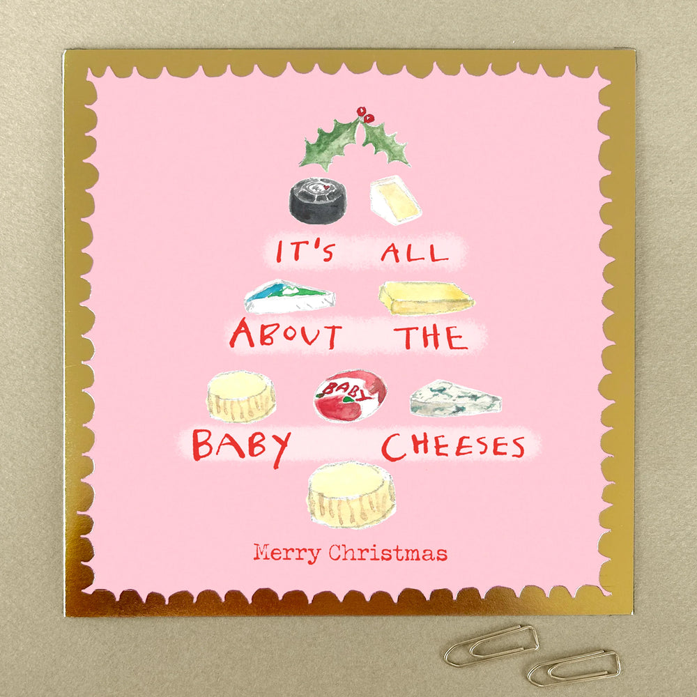 A square Christmas card with a pink background, gold frame and a tree shape made from cheeses.