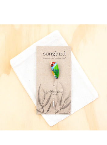 A card that says Songbird with a Lapel or Hat Pin in it with a Gouldian Finch.