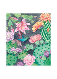 A square watercolor-style art print featuring a desert garden scene with pink flowers, green cacti, purple blooms, and a blue-green hummingbird on a dark gray background, shown centered on a white canvas.
