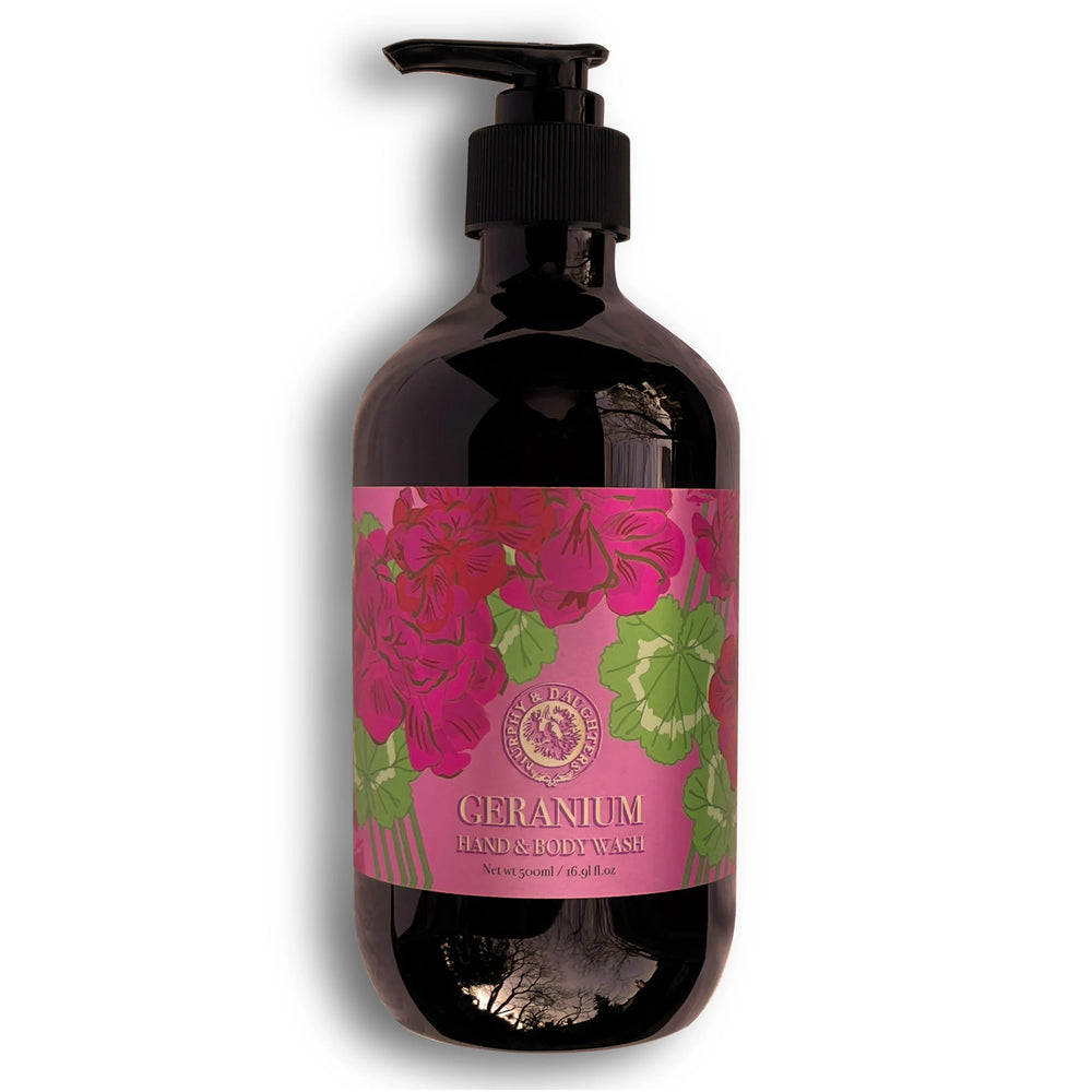A dark amber pump bottle of Geranium Hand & Body Wash by The Body Shop, featuring a pink label with green leaves and magenta flowers, on a white background.