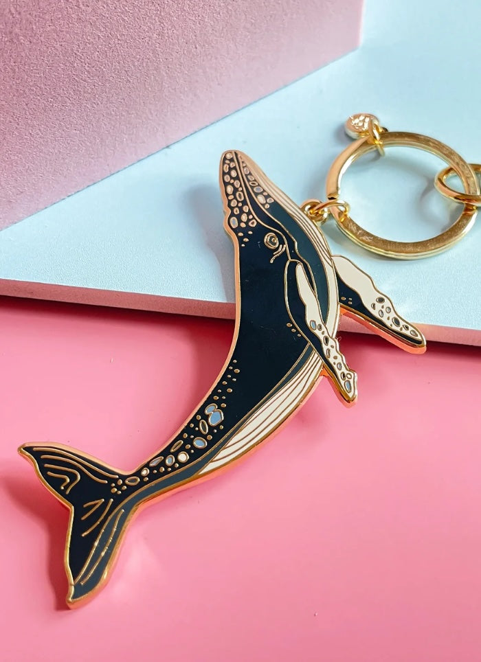 Whale-shaped keychain on a pink and blue background