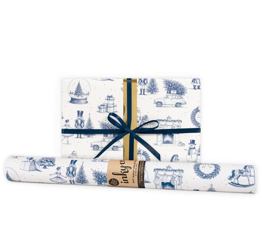 A wrapped gift next to a gift wrap roll in blue and white Christmas design.