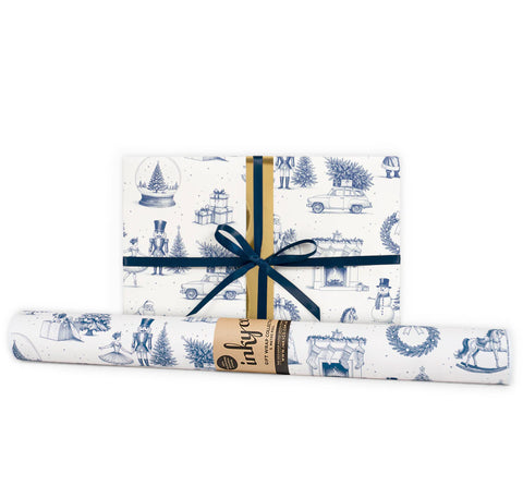 A wrapped gift next to a gift wrap roll in blue and white Christmas design.