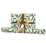 Roll of floral-patterned gift wrap with a gold ribbon and label on a white background