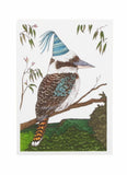 Kookaburra bird wearing a party hat on a branch with leaves in the background
