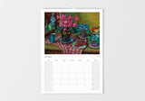 Calendar with a still life painting of flowers and fruit on a table, displayed on a white wall.