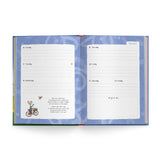 An open weekly planner spread showing two white daily log pages on a blue patterned cover, photographed from above on a light gray background.