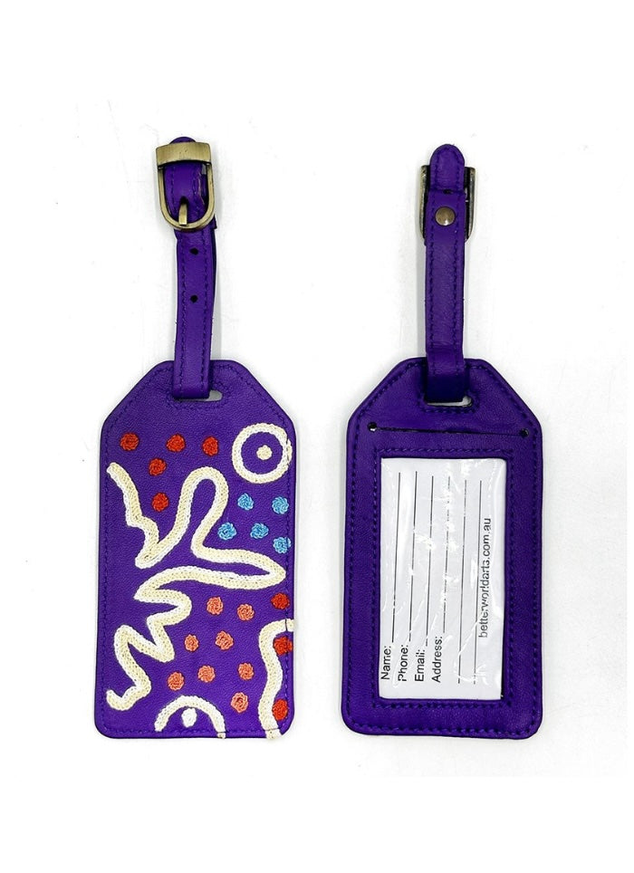 Front and back of a purple emboidered on leater luggage tag.