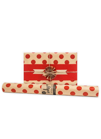 Red and white polka dot wrapping paper with a roll on a white background