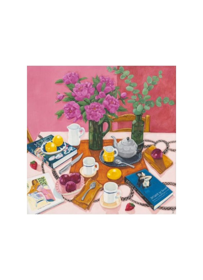 Pink flowers in a green vase on a table with fruit, books and breakfast dishes.