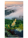 Cover of the Birthday Calendar with an image of cloud over a mountain with flowers in the foreground.