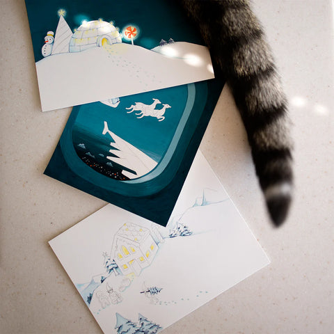 Set of winter-themed greeting cards with illustrations on a textured surface.