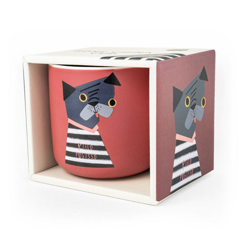 An orange mug with a dog called Pablo Pugasso on it, in it's box. Design my Niaski.