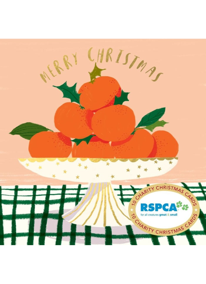 A festive Christmas card illustration featuring a pile of oranges on a pedestal plate with holly leaves, under the words 'MERRY CHRISTMAS.' The card has a peach background, a green-and-white plaid tablecloth, and an RSPCA logo badge at the bottom right.