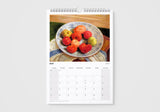 Calendar page for May showing a plate of apples on a table.