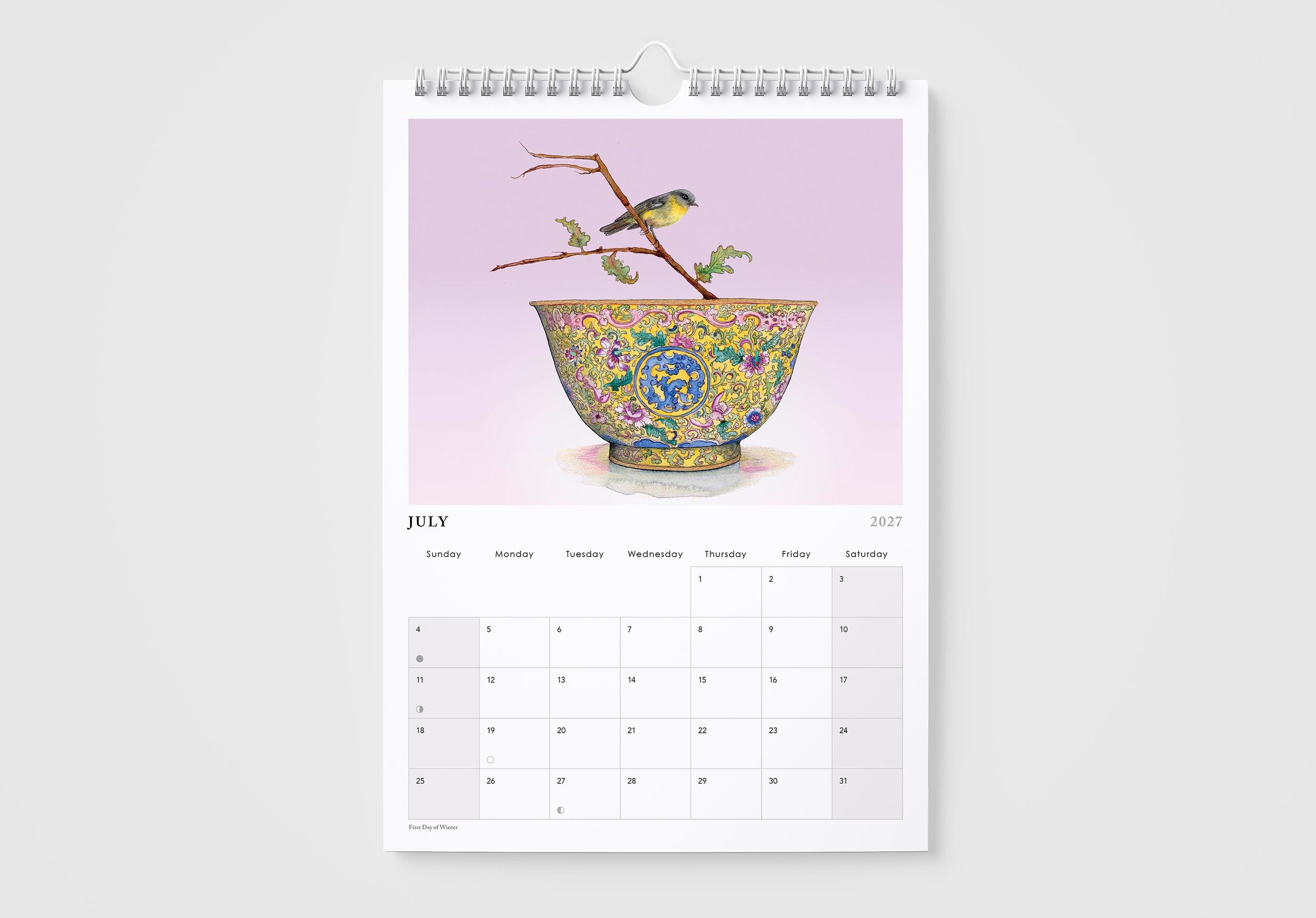 Calendar page for July with a decorative bowl and birds on a branch against a pink background