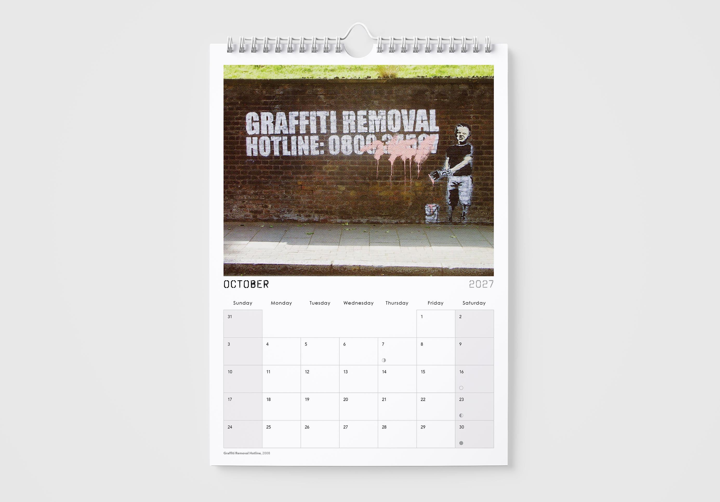 Calendar page for October with a graffiti removal hotline on a wall, on a white background