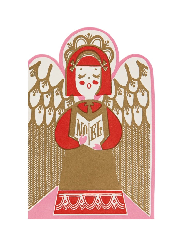 A stylized paper-cut style illustration of an angel with red hair and wings, holding a book with the word 'NOEL' visible, on a white background.
