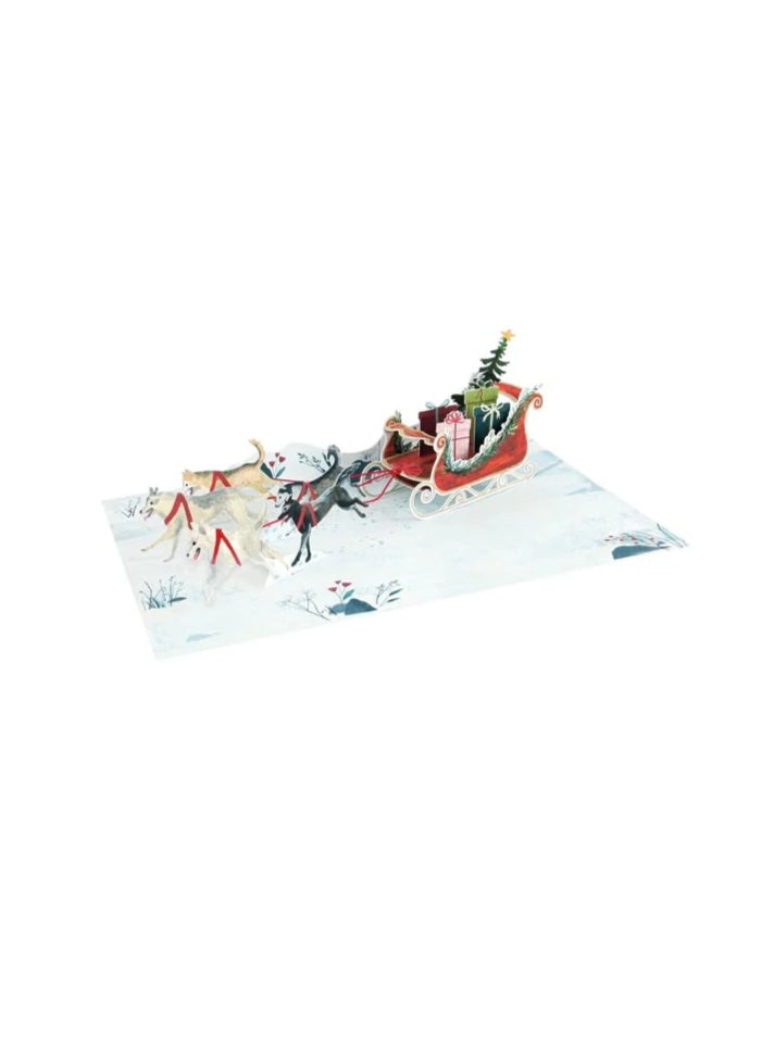 3D pop-up card with Santa Claus in a sleigh pulled by reindeer on a white background