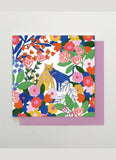 Square card with brightly coloured illustration of cats in flowers
