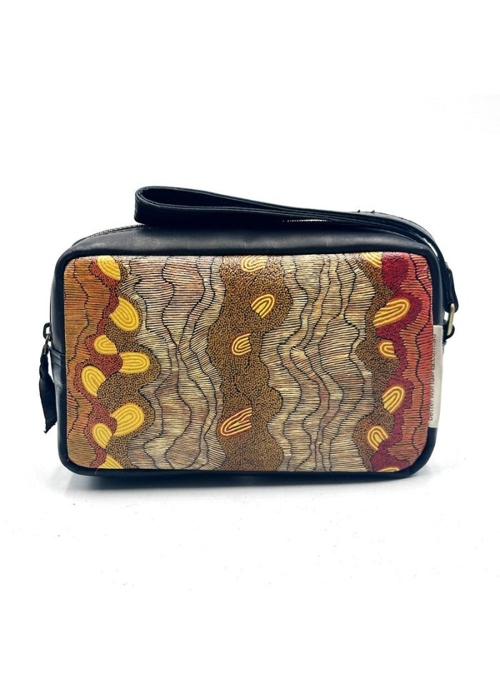 Leather toiletry bag with an Indigenous design in browns and ochre