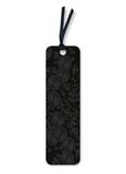 Black floral embossed bookmark with a string on a white background
