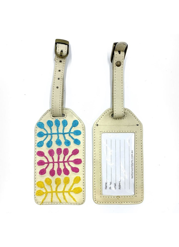 Cream coloured luggage tag with colour embroidery by Mitjili Napurrula