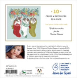Back of a Christmas-themed card pack insert showing 10 cards and envelopes in a pack, with holiday illustrations of three dogs in red, green, and white stockings, product text, a small baby photo, and sponsor logos including Children's Medical Research Institute and Jeans for Genes.