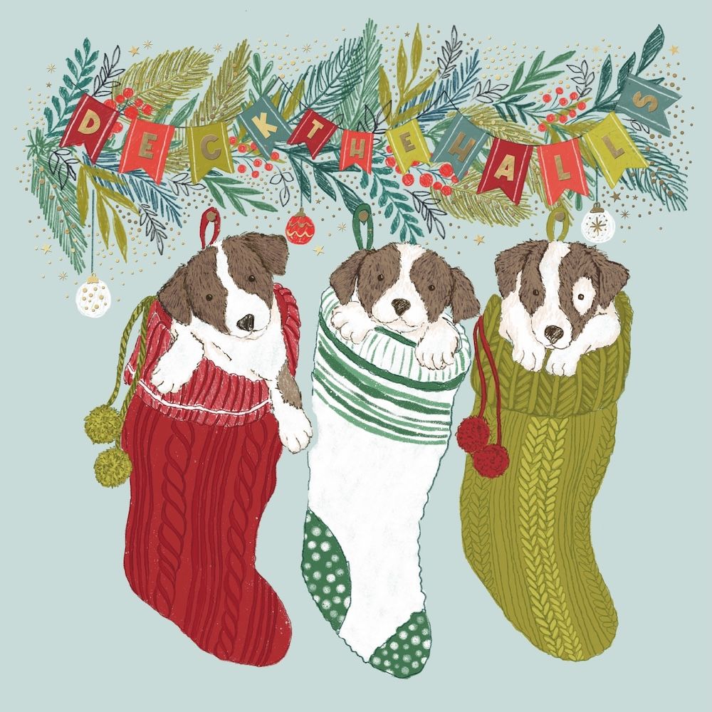 Three dogs in colorful Christmas stockings with festive decorations on a light blue background.