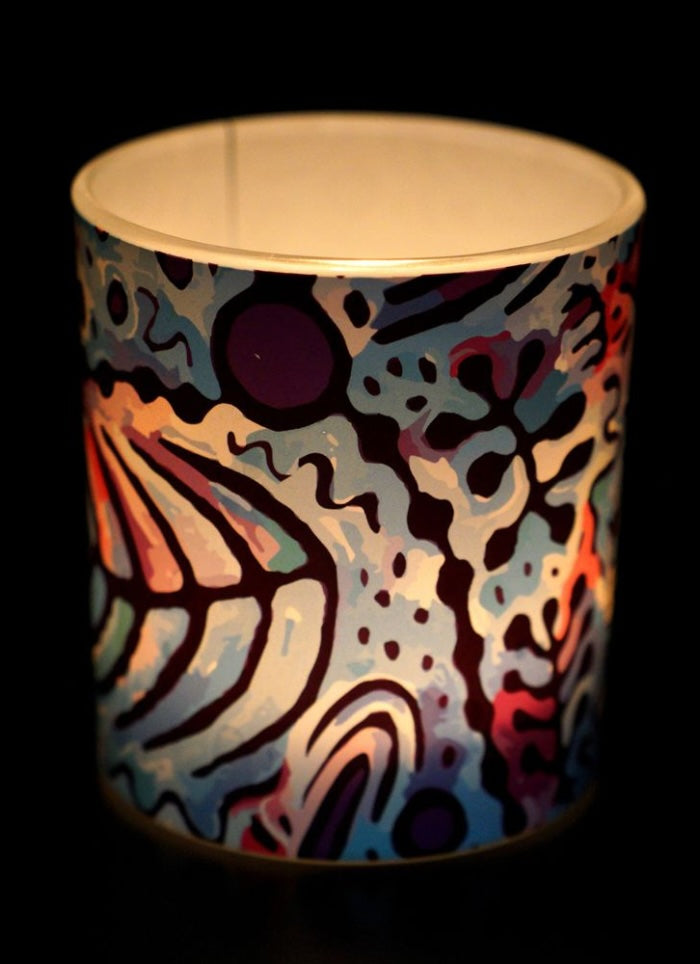 Colorful abstract-patterned container with a gold rim on a black background