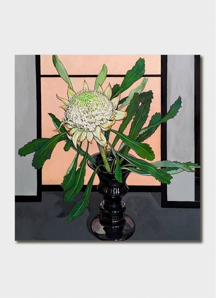 A white waratah with leaves in a vase