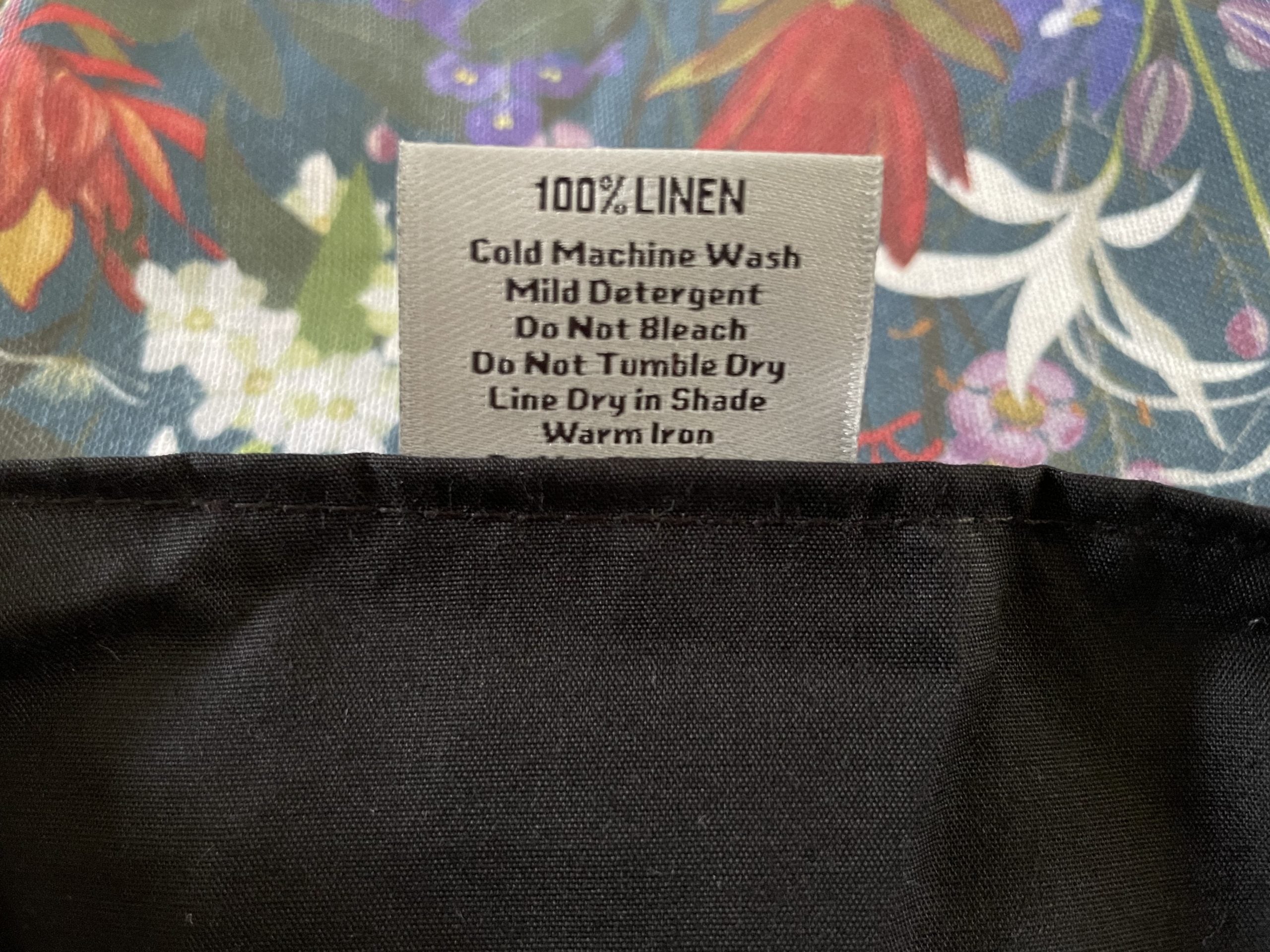 Fabric tag with care instructions on a floral background