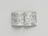 Two coloring books with intricate black and white patterns on a gray background