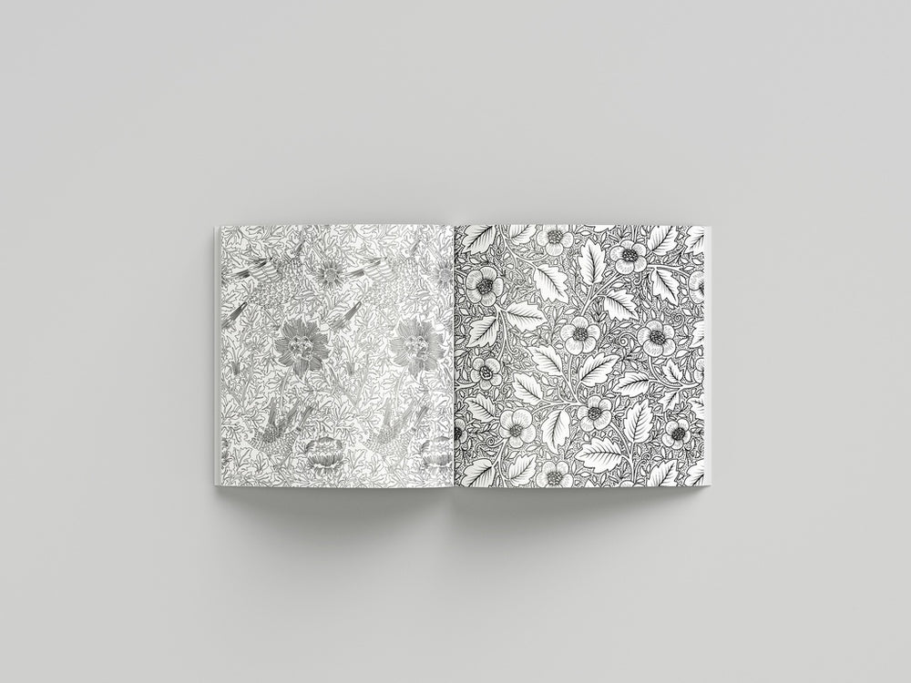 Open book displaying black and white floral patterns on a gray background