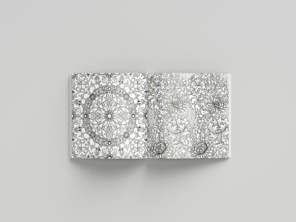 Coloring book open to pages with intricate black and white mandala designs on a gray background