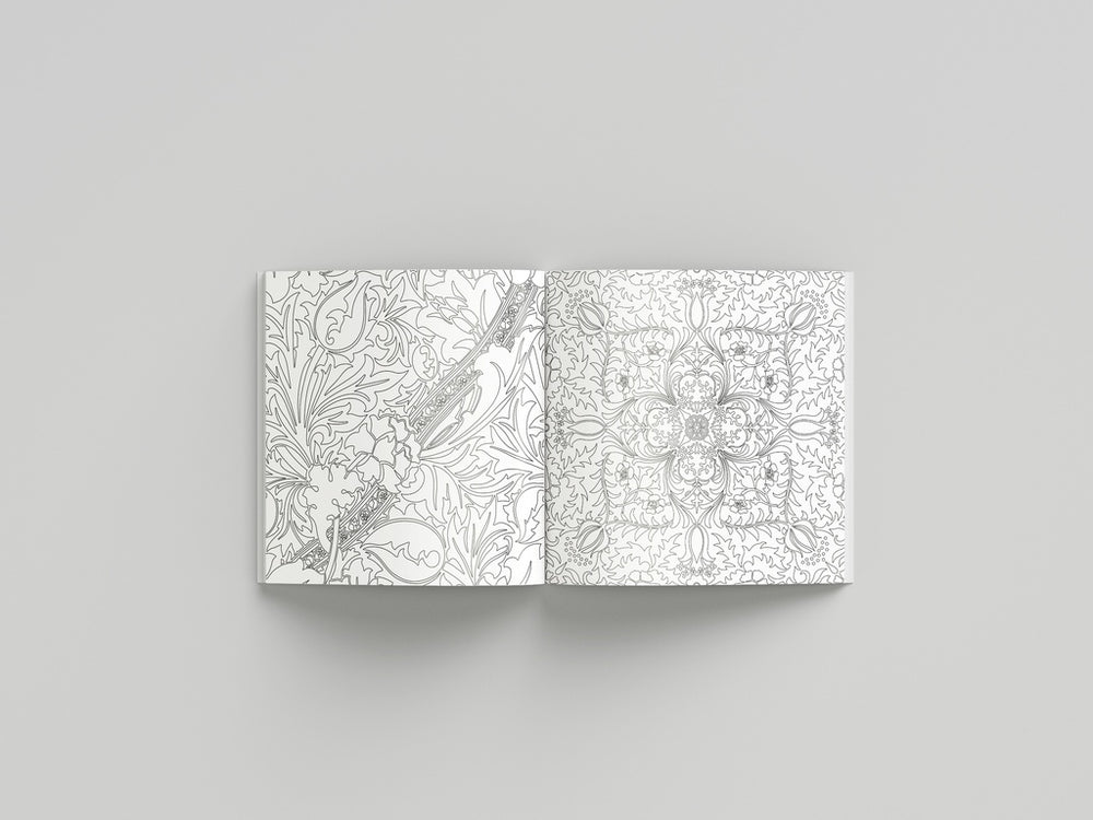 Open coloring book with intricate black and white patterns on a gray background