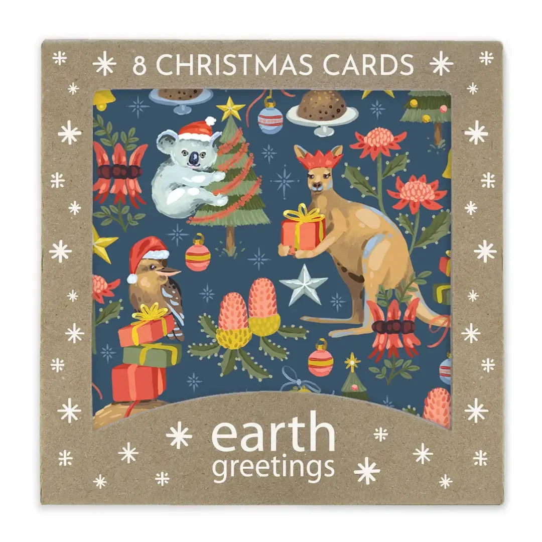 A square package of Earth Greetings Christmas cards featuring a festive illustrated design with a koala, kangaroo, bird, gifts, trees, and flowers on a dark blue background, surrounded by a tan border with white snowflake motifs and the text '8 CHRISTMAS CARDS' and 'earth greetings'.