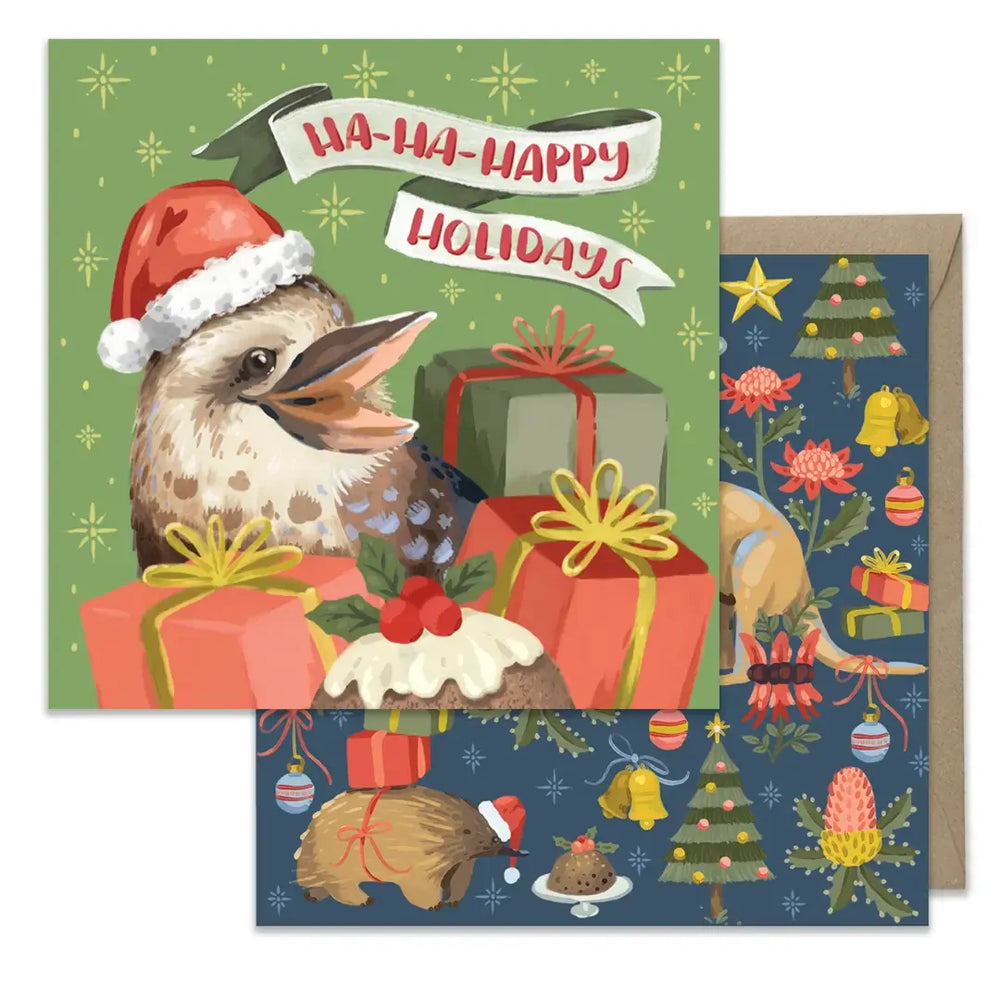 A Christmas greeting card set featuring a kookaburra wearing a Santa hat among wrapped gifts on a green background, with a navy blue envelope showing holiday illustrations.