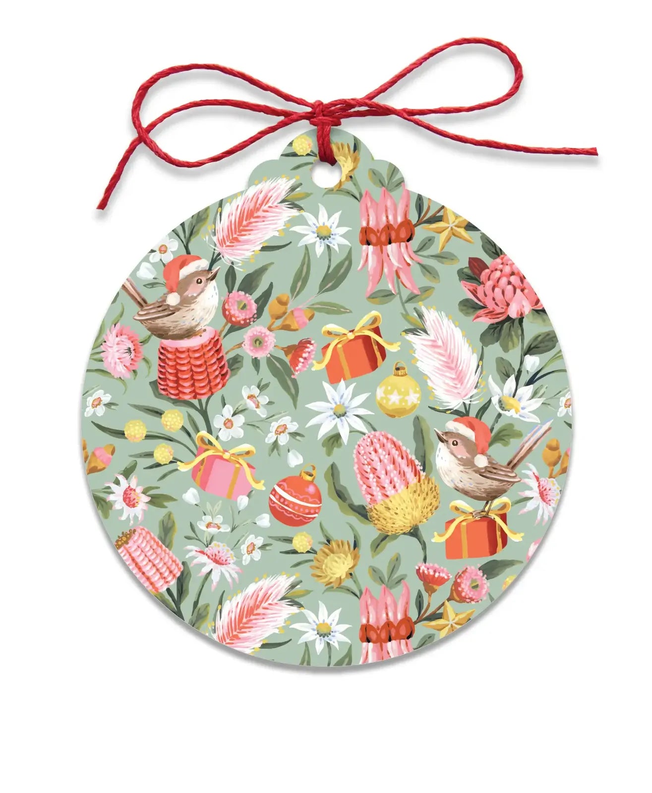 A round hanging ornament with a red string bow at the top, featuring a whimsical floral and bird pattern in pink, red, yellow, green, and white on a muted sage background.