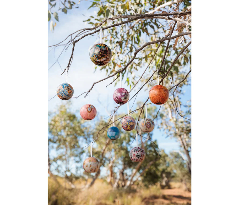 Decorative decorations hanging from a gum tree with blue sky in the background.