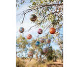 Decorative decorations hanging from a gum tree with blue sky in the background.