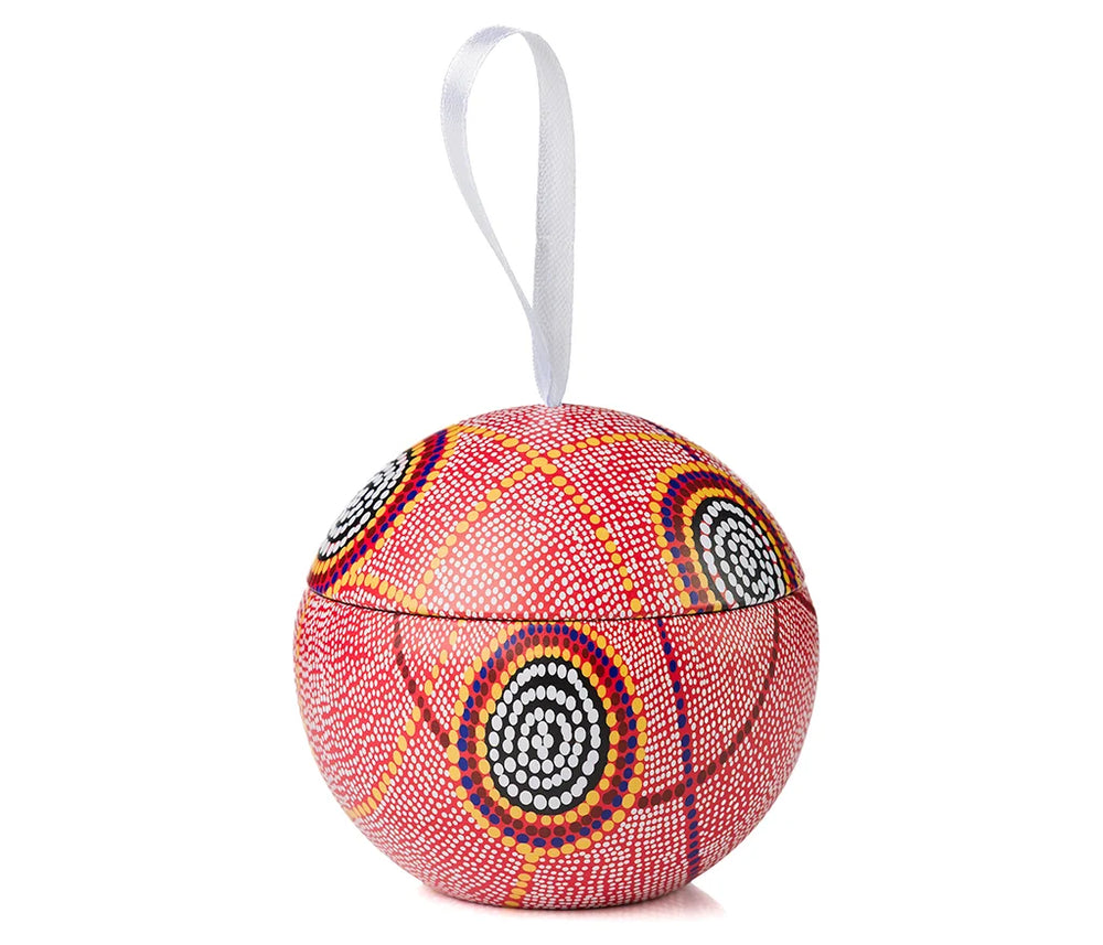 A Christmas bauble with Aboriginal art hanging from a ribbon on a white background