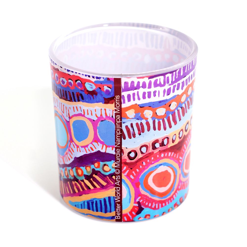 Colorful patterned candle in a glass container on a white background