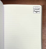 Open notebook with lined pages on a wooden surface, featuring 'Flame Tree Lined Pages' branding.