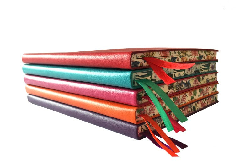 Stack of colorful books with decorative ribbons on a white background