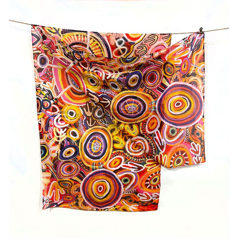 Colorful abstract patterned fabric hanging on a line against a white background